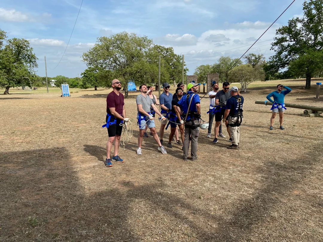 Photo of several Invisible AI staff members holding a rope for tightrope walking